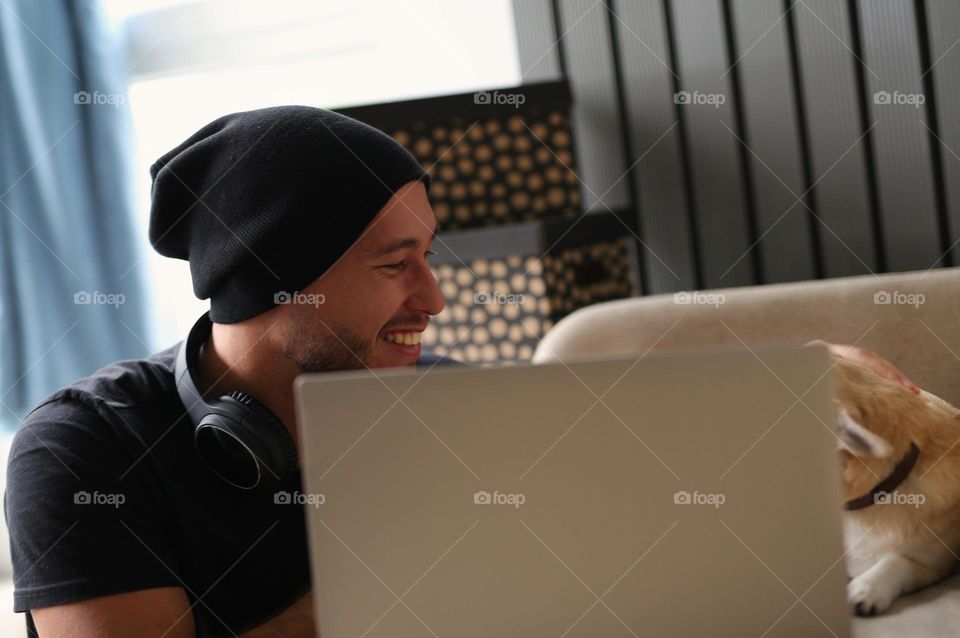 stylish guy in black clothes, with headphones and his best friend, a dog. a twenty-three-year-old teenager, a new generation.