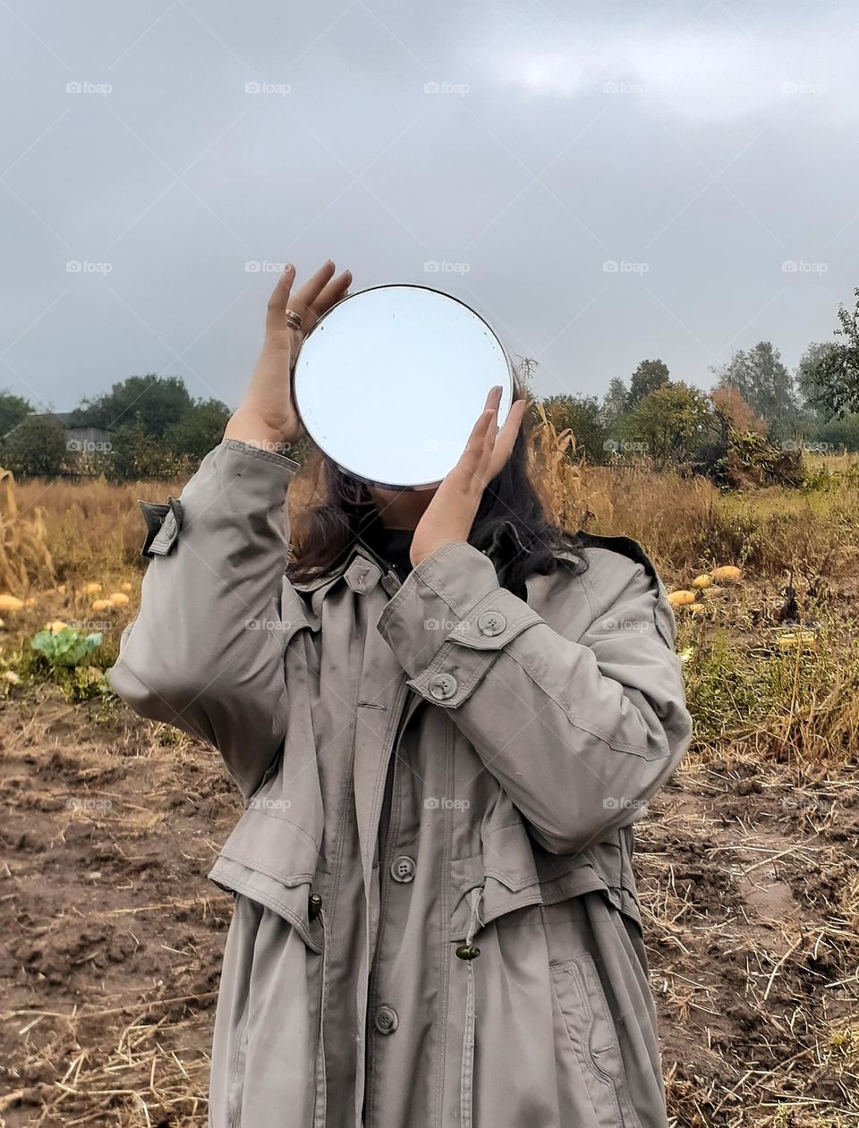 Portrait of a girl with a mirror instead of a face with a reflection of the sky