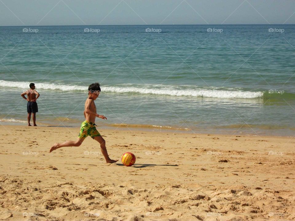 Playing football all day long on the beach... It's Summertime