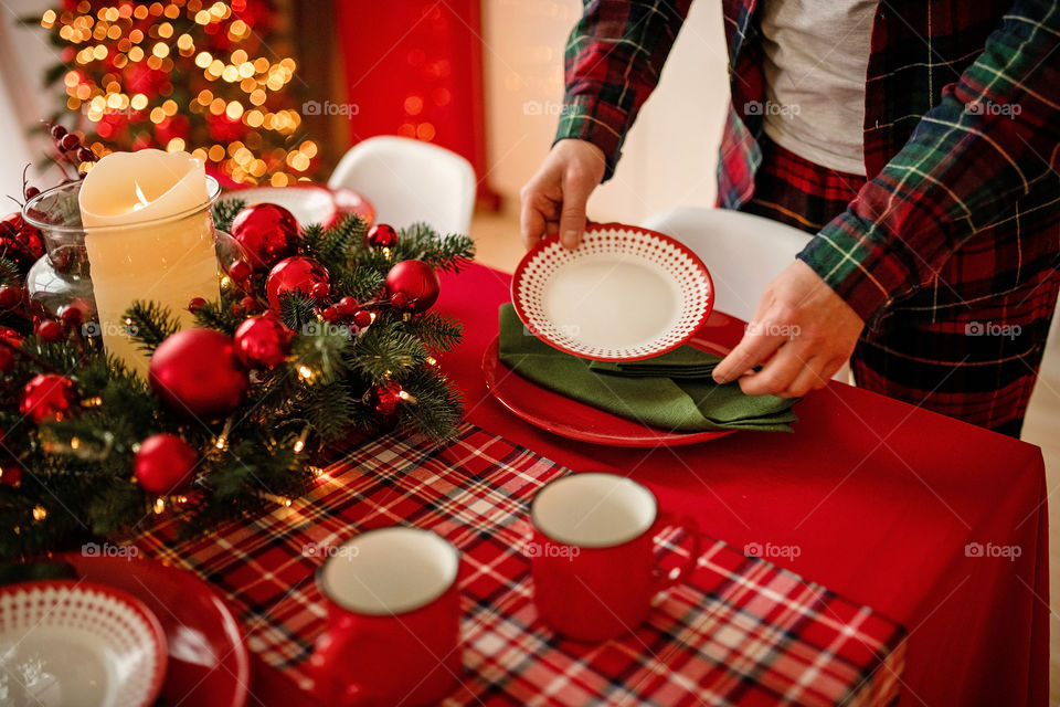 man sets a beautiful decorated winter table for a festive dinner.  Merry Christmas and Happy New Year.