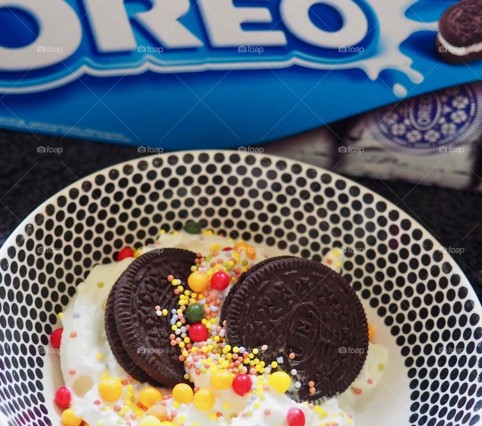 Oreo cookies with whipped cream and sprinkles.