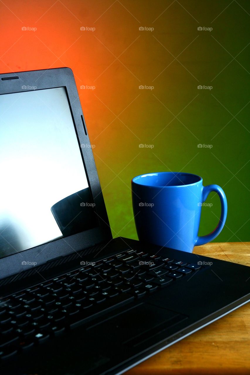 laptop computer and blue coffee mug
