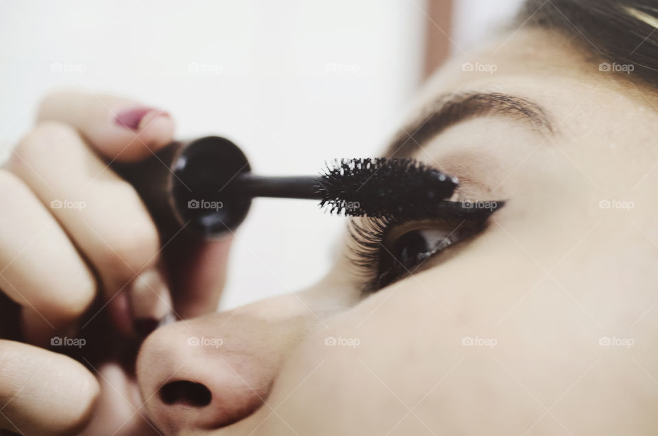 Woman putting mascara on 
