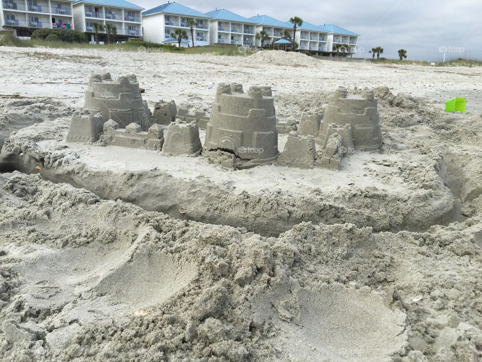sand castle at the beach with hotels in the background 