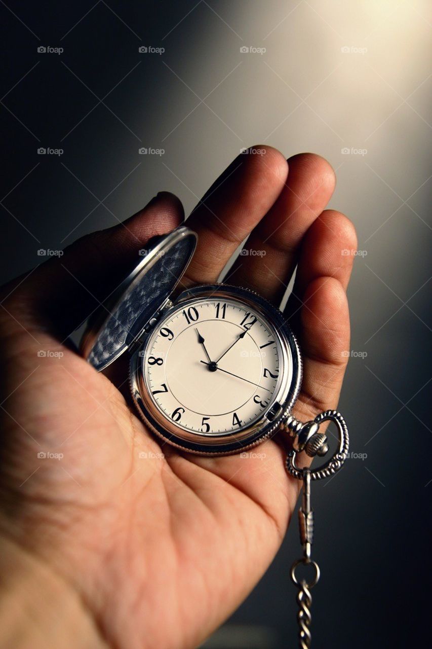 Hands cupping a watch