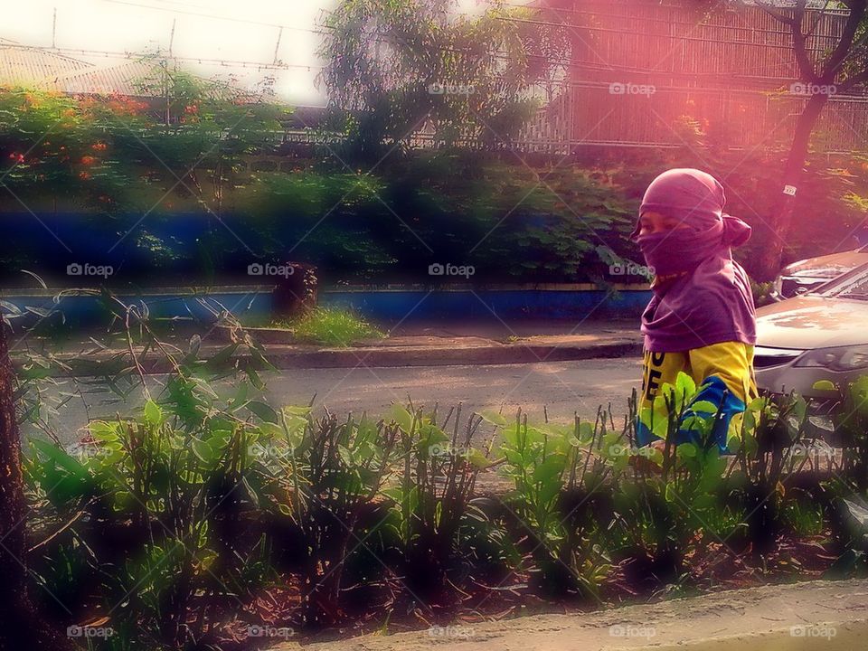 Street sweeper covers her face as protection from pollution