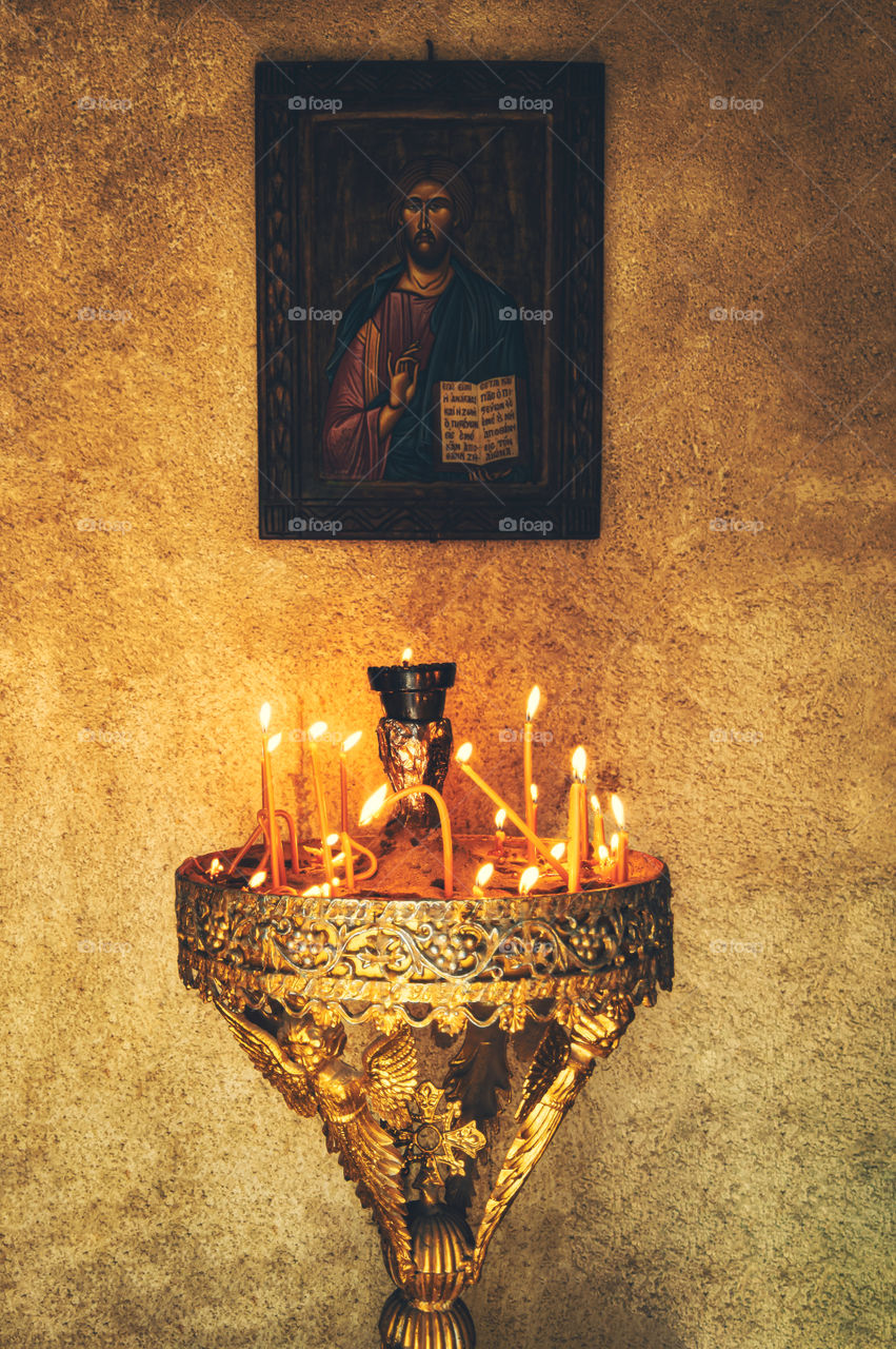 Icon. Religious work of art illuminated by candles. No translation.