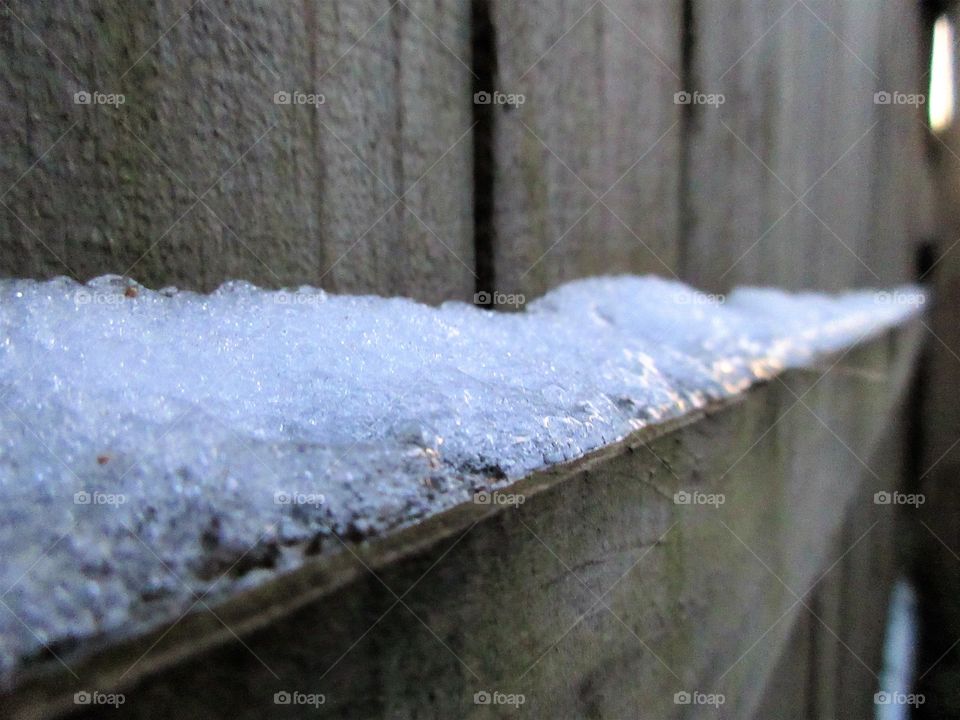 melting snow on fence