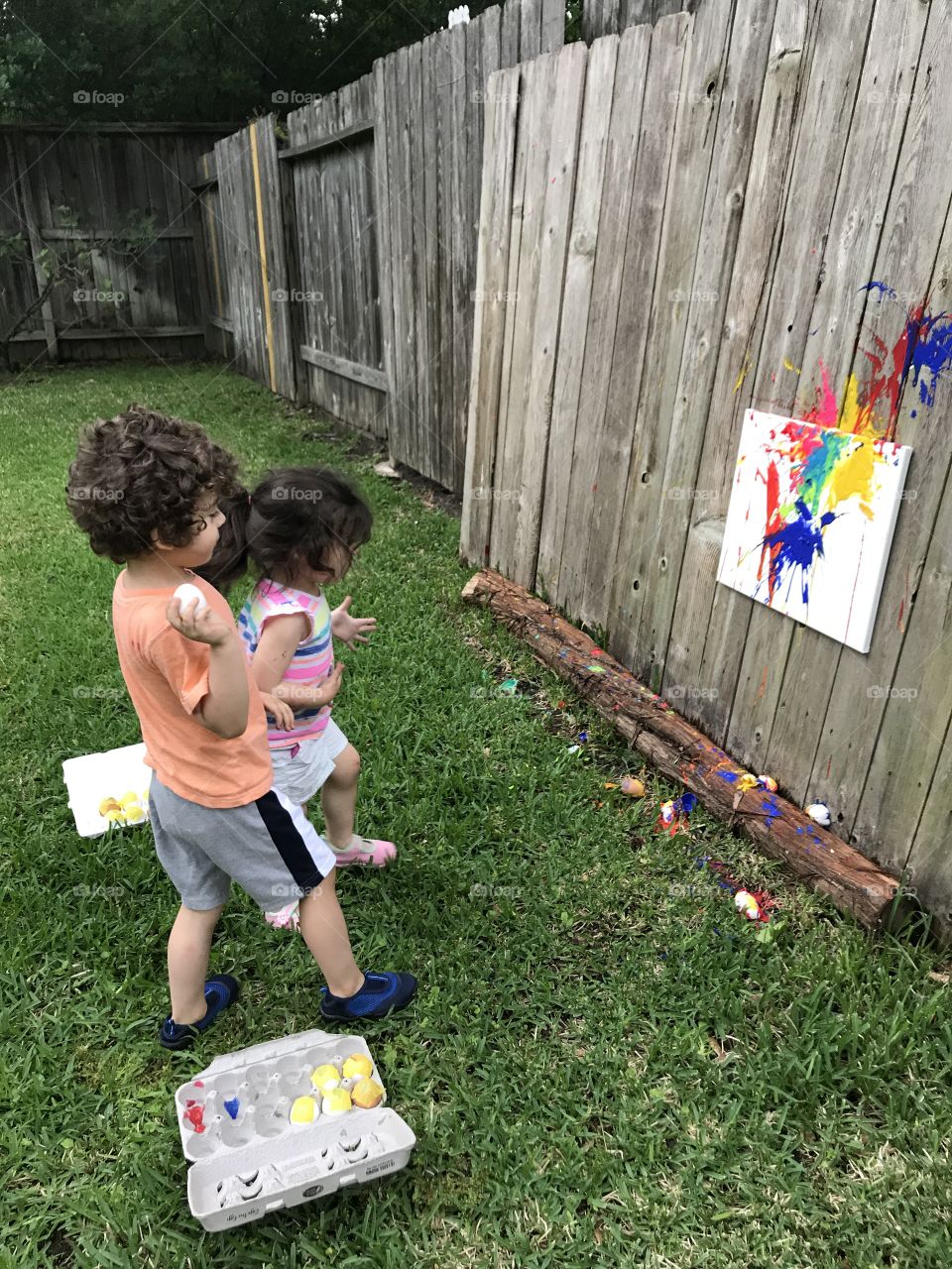 My kids enjoying a fun filled activity that included throwing eggs filled with different paint colors at a canvas. Creating a unique kind of art. 