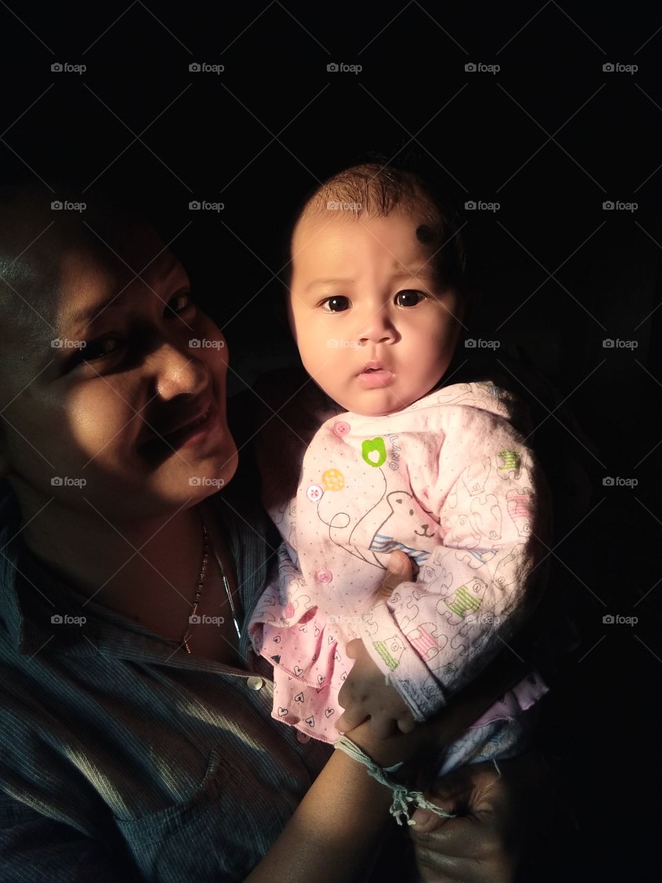 cute baby in a dark place with aunty looking cute