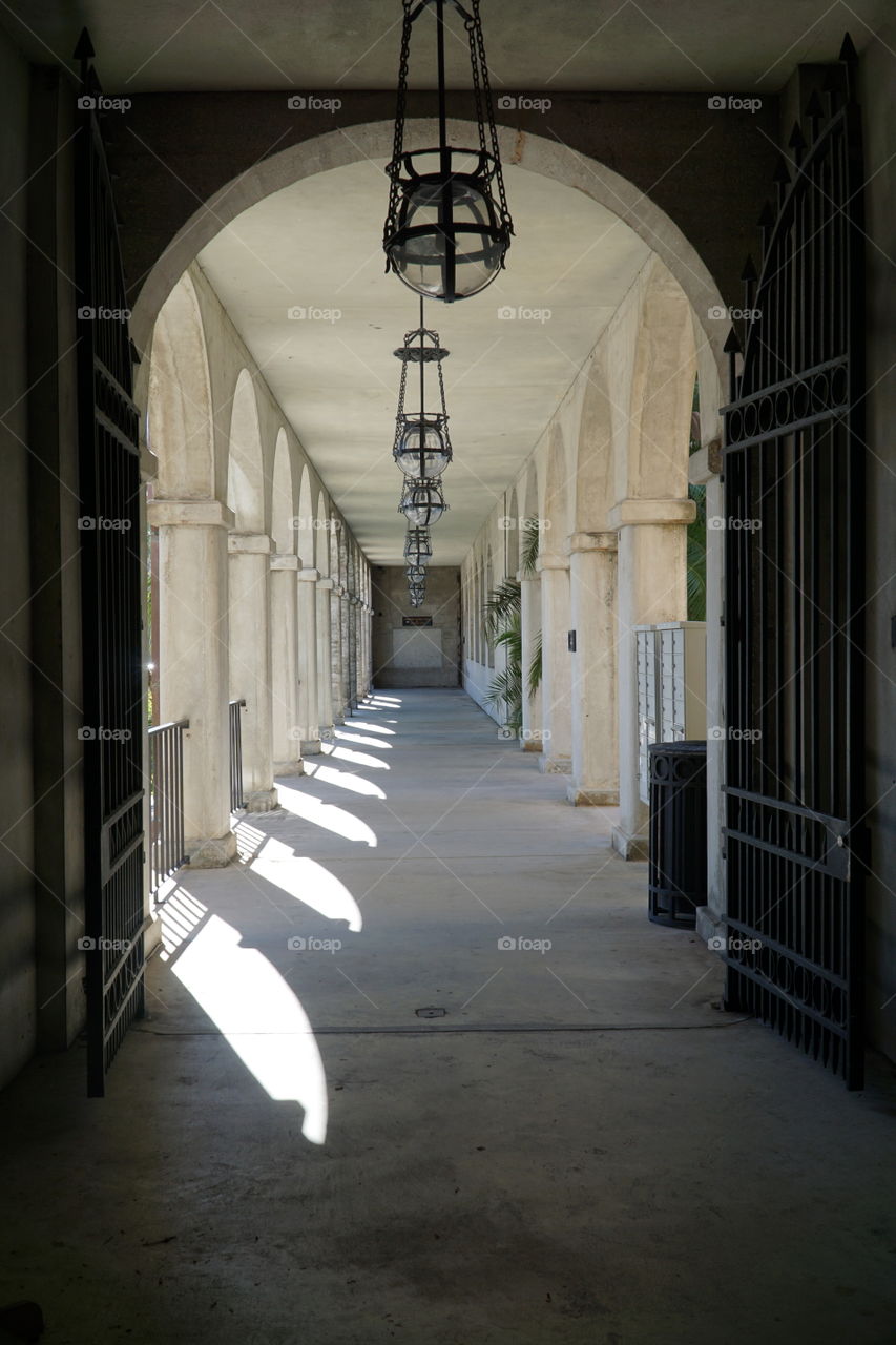 Colonnade with lanterns and sun shining through 