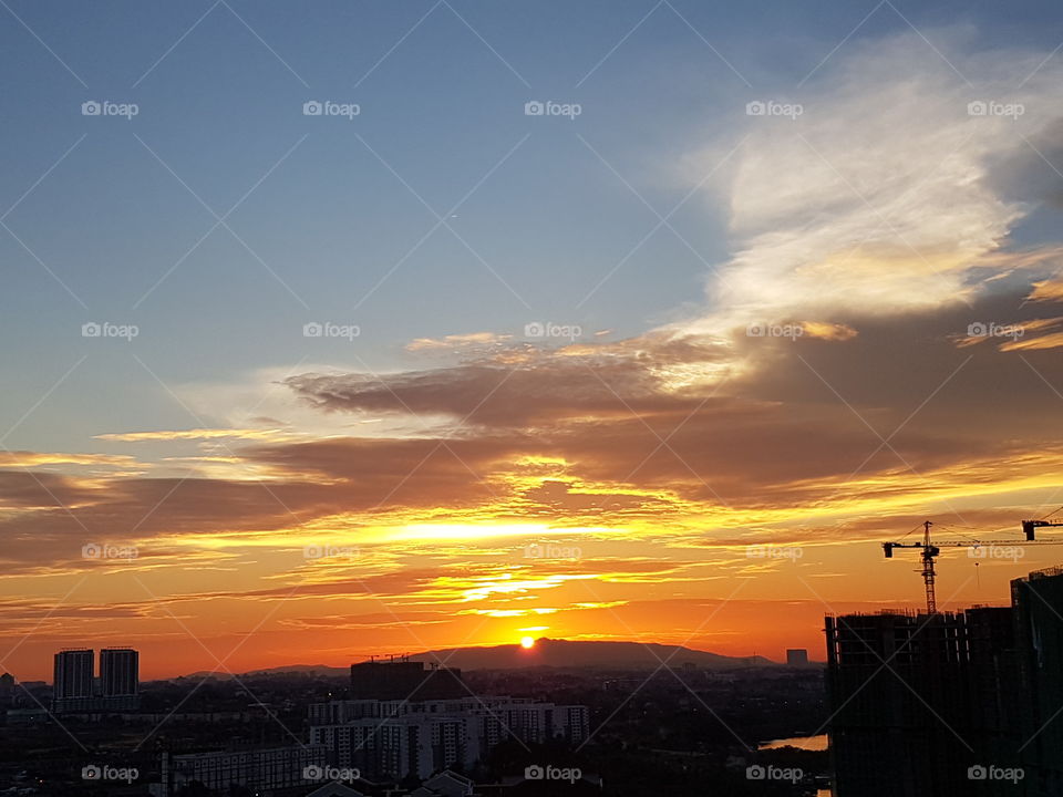 Orange sunset and silhouette over cityscape
