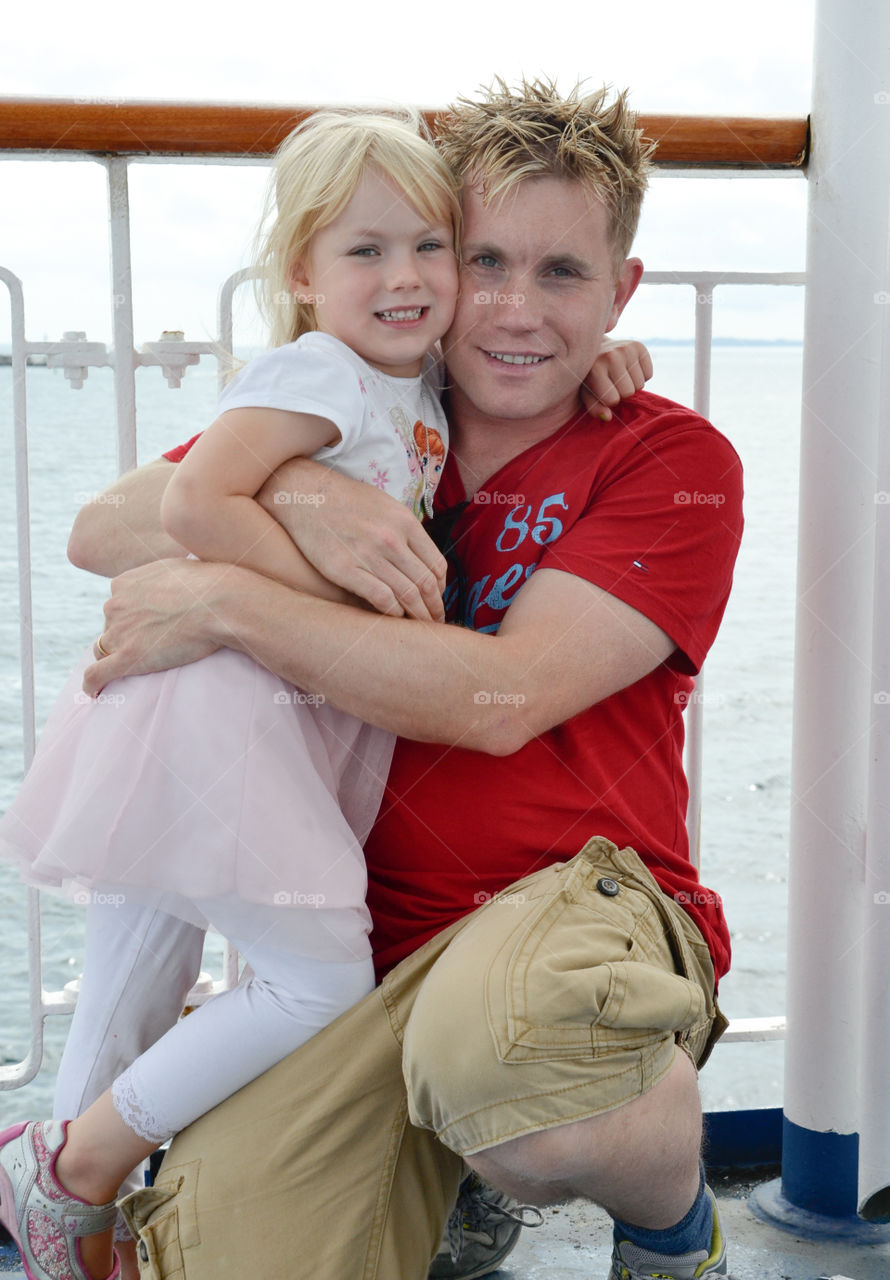 Father and doughter hugging on a boat.