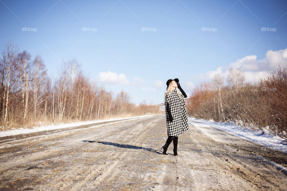 girl in a coat and hat on the road