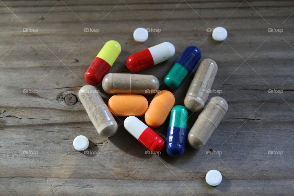 Various pills on a wooden table