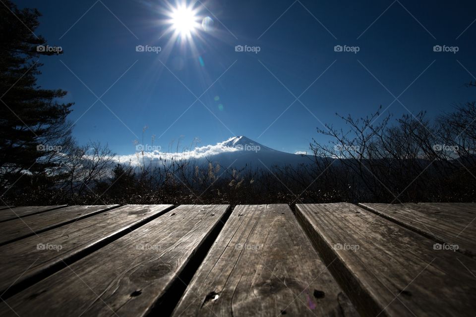 I had a good opportunity to go to Mt.Tenjo San for impression with sight seeing in the morning of Mt.Fuji after that i walked on mountain ridge for finding a new view point to take a photo.Suddenly,i noticed a shining sun above view of the Fuji mountain and then i took it by using the front scene was a bench.