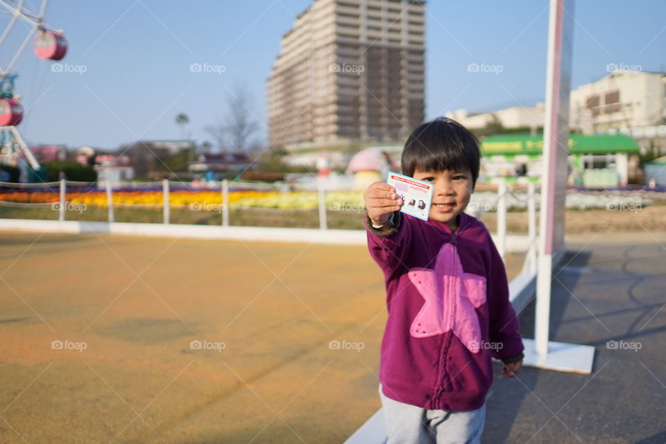 Japanese boy showing amusement park ticket 