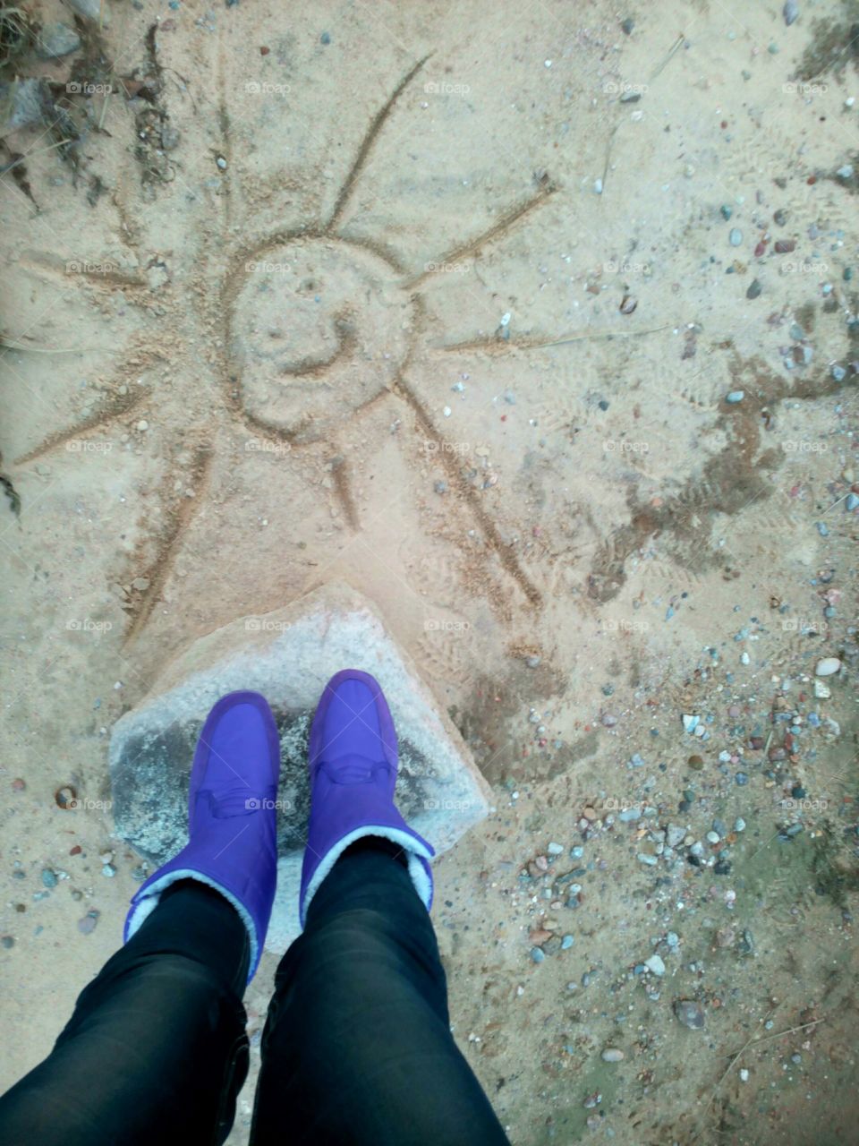 boots and drawing sun in sand