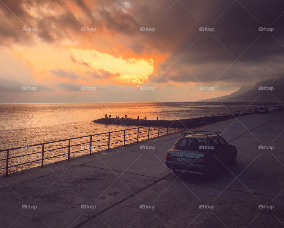 Car on the seaside watching sunset. 