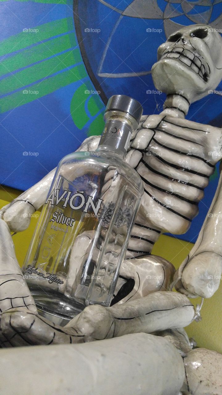Skeleton holding a bottle of tequila