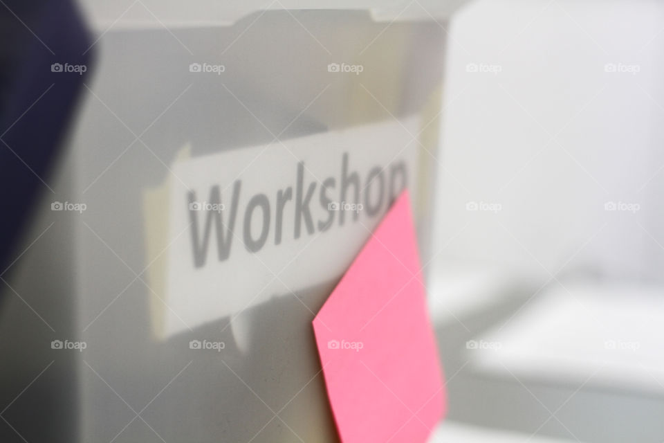 A plastic bin marked "workshop" with supplies inside