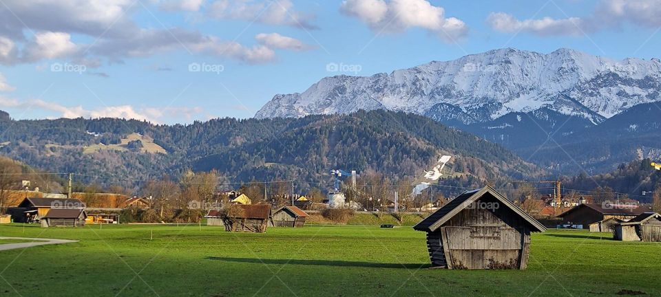 Farmhouses, sheds, barns, houses, meadows and mountaintops can be seen here in the vicinity of “Garmisch Partenkirchen”, a small town and ski resort in the Bavarian Alps. 2023. Hypnotic Productions