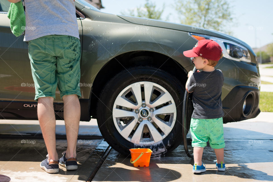 Dad and son cleaning the car