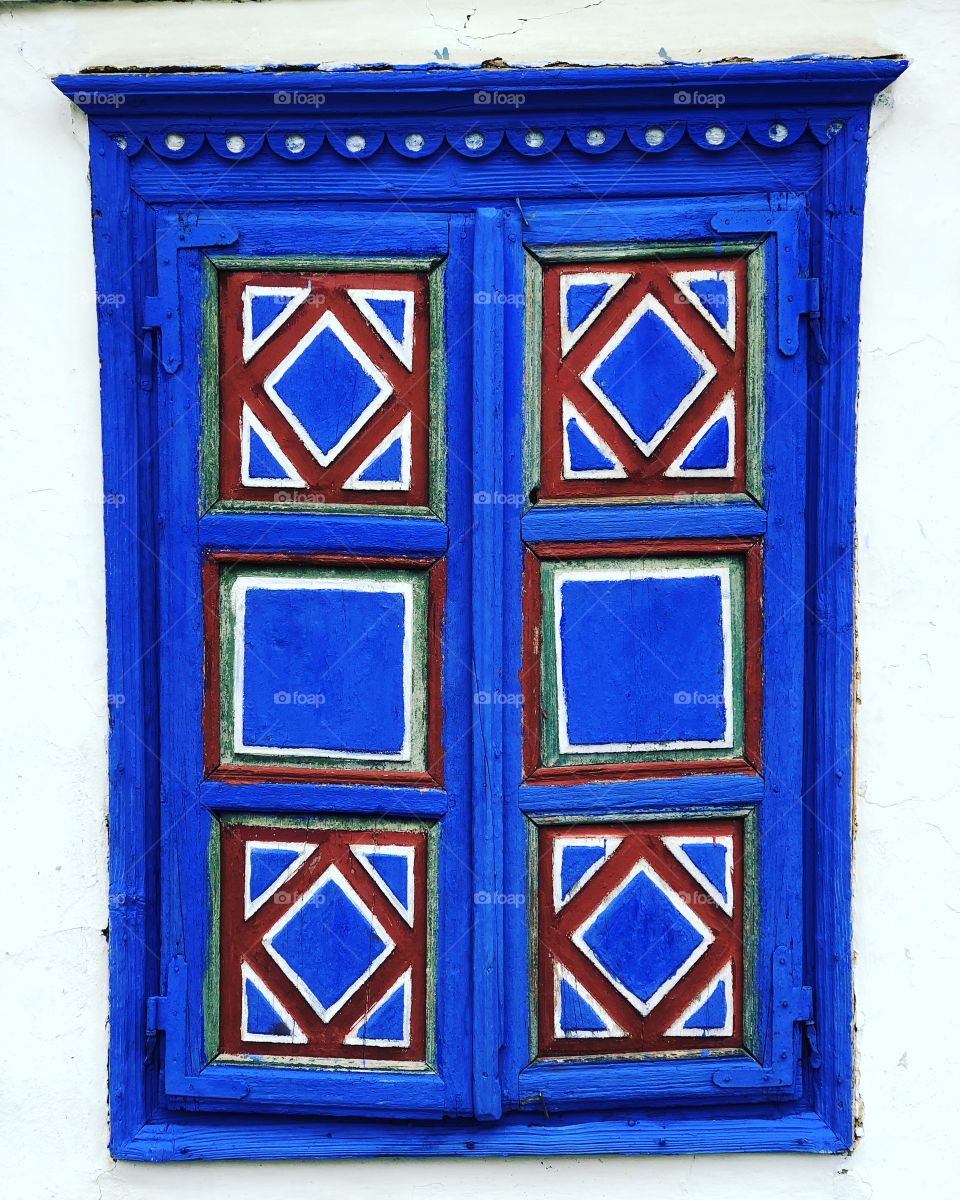 An old painted window shutter on a traditional Romanian house at the village museum, Bucharest