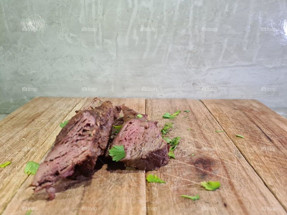 Wood cutting board with cut beef