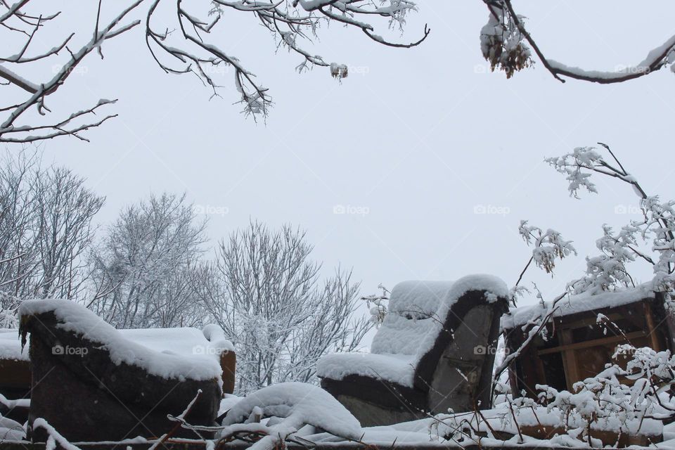 Discarded old furniture covered with snow