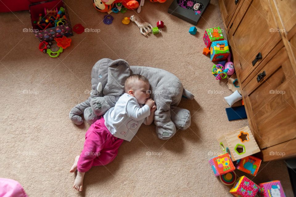 Sleeping baby on elephant plush toy.