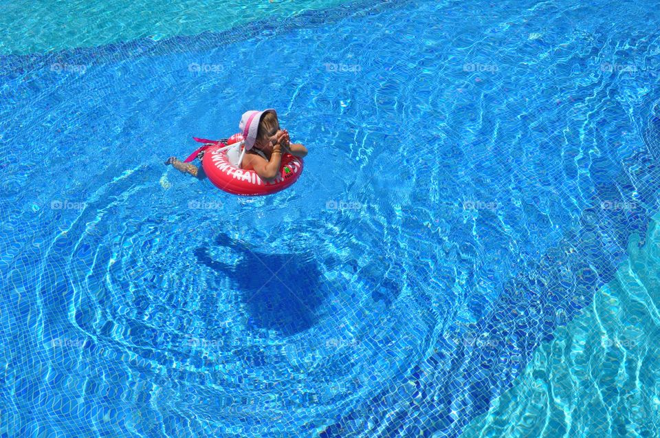 Girl swimming in the pool with inflatable ring
