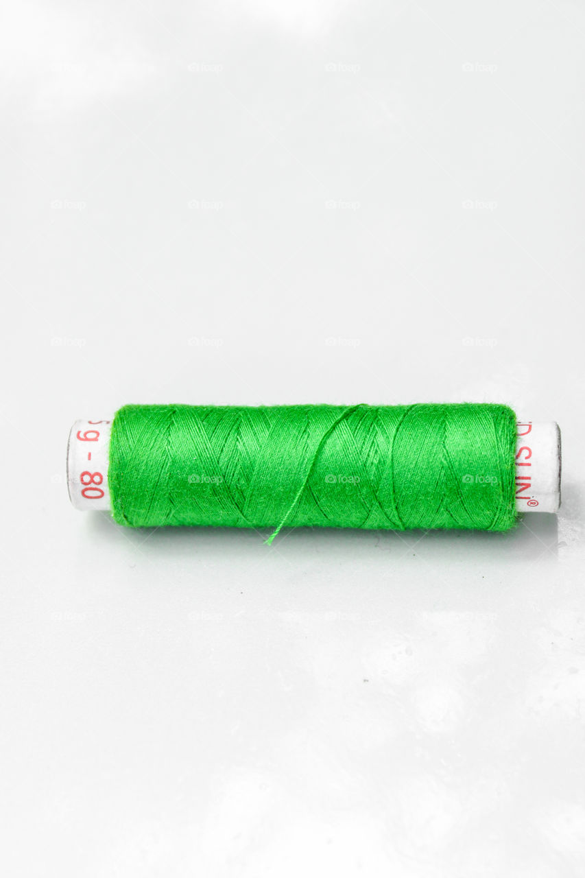 Green colour stitching thread with white colour background