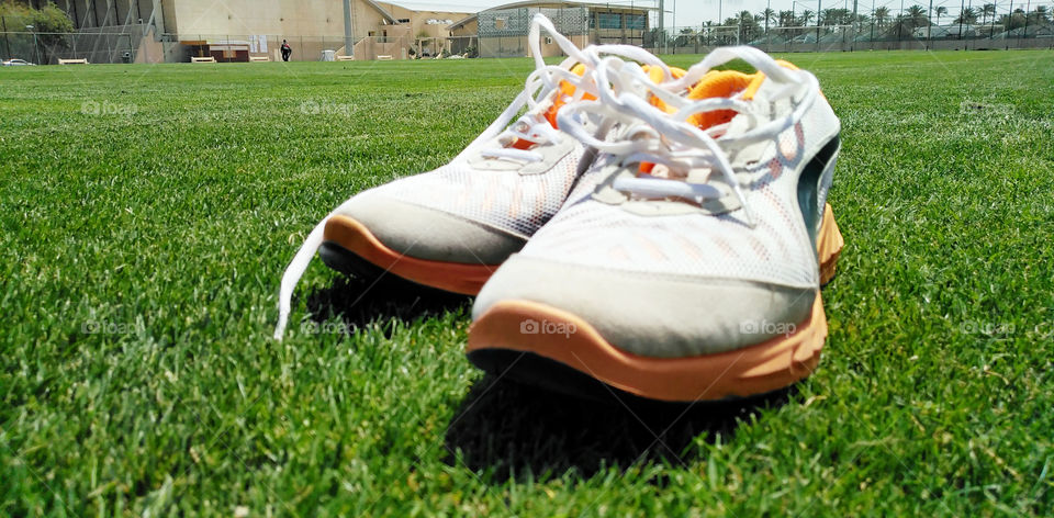 Football shoes on green football yard