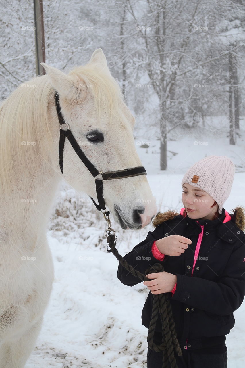 Teenage girl with horse in winter