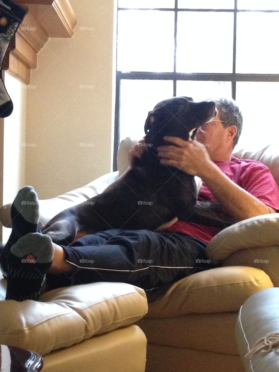 Mature man sitting of sofa with dog