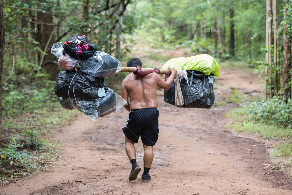 Man carrying a lot of bag in their shoulder in Phu Kradueng national park Loei Thailand 