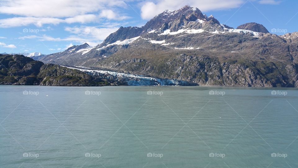 Tall Mountain with snow and Ocean view from cruise ship balcony traveling the inside passage