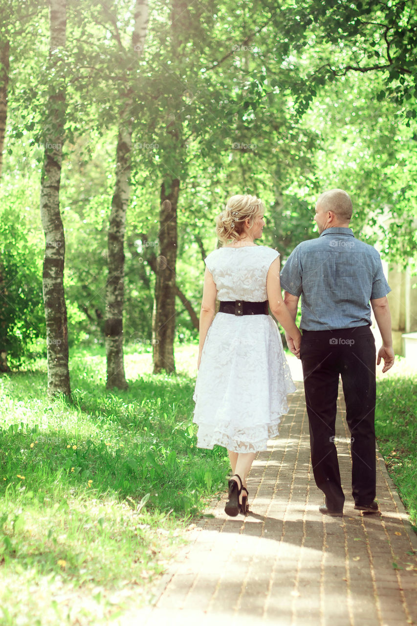 man and woman are walking in the park