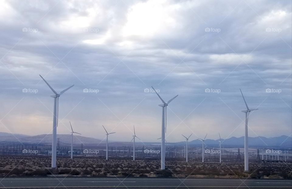 Wind turbines in the desert on a cloudy day.