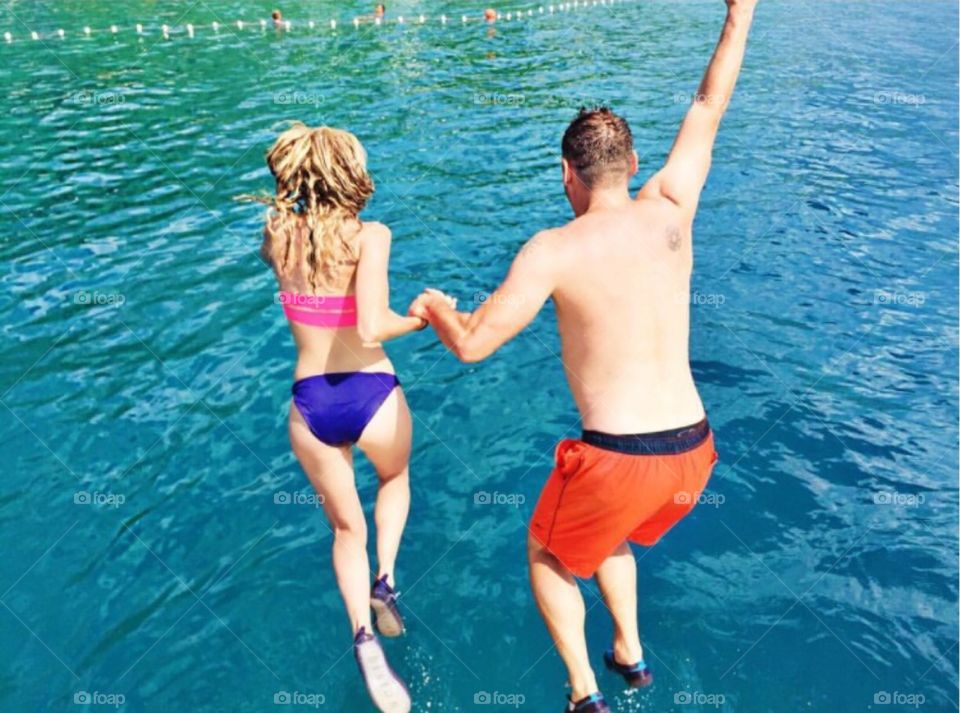 Holding hands while jumping into the sea