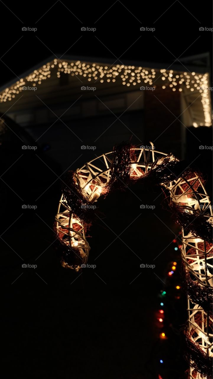 Christmas lights on roof and candy cane in driveway