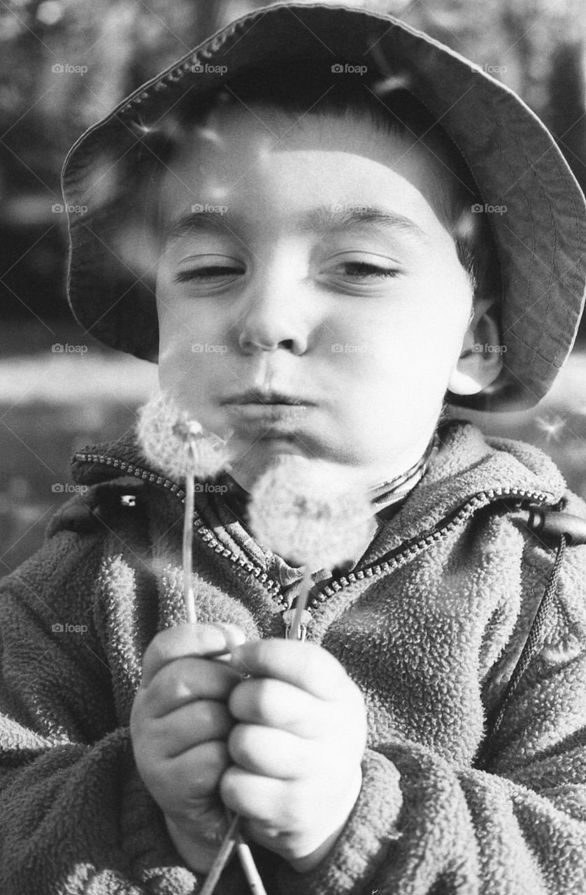 Boy blowing the dandelion