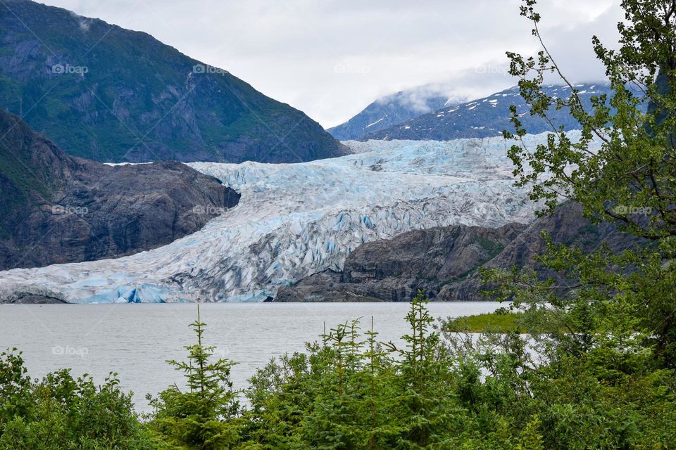 The iconic and beautiful Mendenhall Glacier in Alaska hugs the mountains like a cool cap
