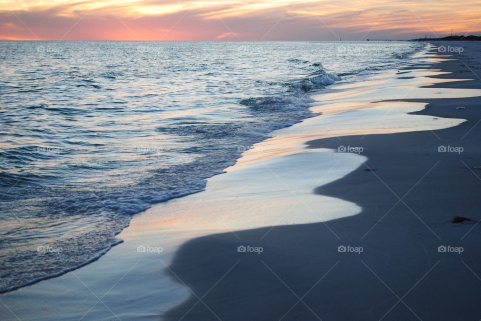 Waves at beach during sunset