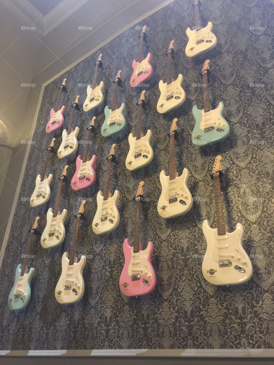 White, pink and blue guitars hang on the wall of fame; the Hard Rock wall of fame.