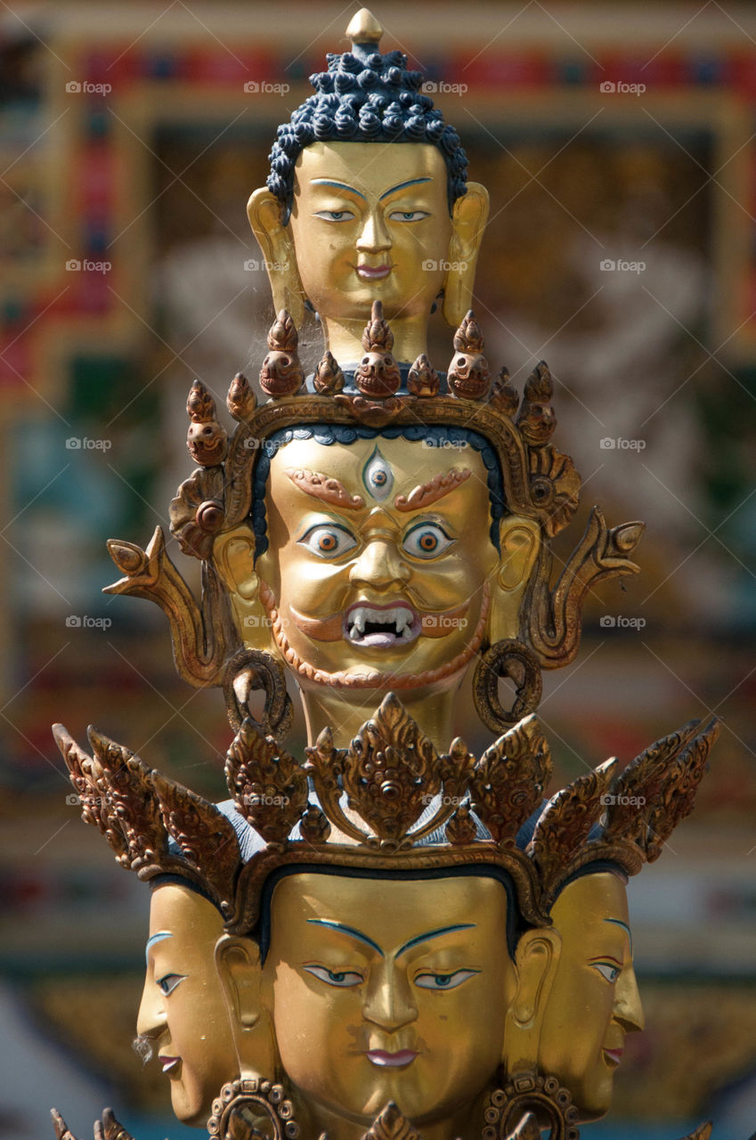 Buddhist golden statue with buddha heads in Kopan Monastery near Boudha, Nepal.