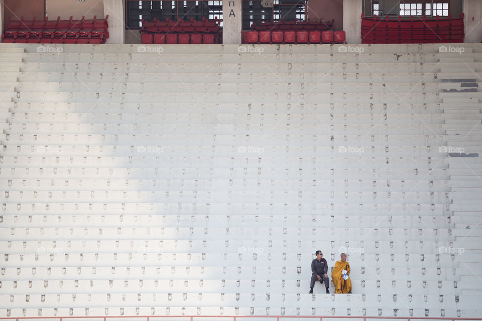 Police and monk in the empty stadium 