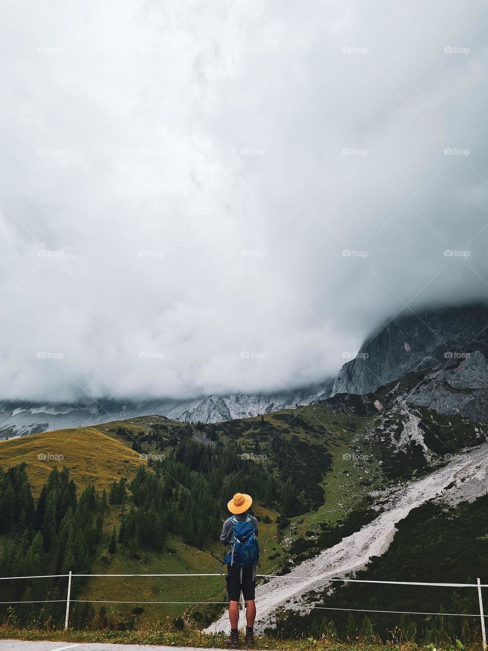 man looking at the clouds covering the mountain tops