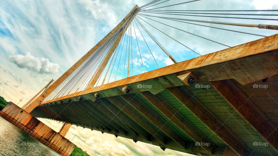 Ponte sobre um rio, suspensa, de concreto e cabos. Divisa de Estados. MS e MG, Brasil.